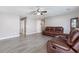 Spacious living room with gray walls, and hardwood floors, featuring an inviting leather sofa and a ceiling fan at 106 Maypop Dr, Goose Creek, SC 29445