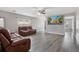 Well-lit living room boasts sleek hard wood floors, neutral walls, ceiling fan, and stylish leather furniture at 106 Maypop Dr, Goose Creek, SC 29445