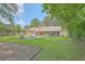 Spacious backyard with brick home, patio, screened in porch, firepit, and framed garden area at 110 Clubhouse Rd, Summerville, SC 29483