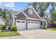 Angled view of a Craftsman-style home with a two-car garage, gray siding, and neat landscaping at 1115 Old Field Dr, Summerville, SC 29483