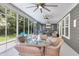 Comfortable sunroom featuring wicker furniture, ceiling fans, and walls of windows overlooking the landscaped backyard at 1115 Old Field Dr, Summerville, SC 29483
