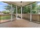 Back porch with wood flooring, white posts, and a view of the backyard and fence at 114 Marshside Dr, Summerville, SC 29485