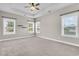 Spacious bedroom with tray ceiling, carpeted floor, and three large windows at 114 Marshside Dr, Summerville, SC 29485