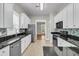 Bright kitchen with stainless steel appliances, white cabinets, black countertops and stone tile backsplash at 114 Marshside Dr, Summerville, SC 29485