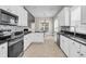 Bright kitchen with stainless steel appliances, white cabinets, black countertops and stone tile backsplash at 114 Marshside Dr, Summerville, SC 29485