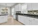 Bright kitchen with stainless steel dishwasher, white cabinets, black countertops and stone tile backsplash at 114 Marshside Dr, Summerville, SC 29485