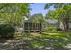 Well-maintained home features a lush backyard with a covered porch and mature palm trees at 116 Cartright St, Daniel Island, SC 29492