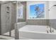 Modern bathroom with a glass shower and a soaking tub under a bright window at 117 Palfrey Dr, Ridgeville, SC 29472