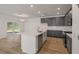 Bright kitchen boasts gray cabinets, stainless appliances, and an island with seating overlooking the dining area at 117 Palfrey Dr, Ridgeville, SC 29472