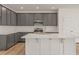 Well-equipped kitchen featuring gray cabinets, island with white counter, and backsplash at 117 Palfrey Dr, Ridgeville, SC 29472