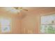 Simple bedroom with a ceiling fan, two windows and neutral-toned walls at 1203 Hawthorne Rd, Hanahan, SC 29410