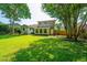 Expansive backyard with lush greenery, trees, and a partial view of the home's brick and yellow siding at 1369 Miles Dr, Charleston, SC 29407