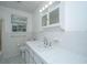 Bright bathroom featuring white tiled walls, a vanity with storage, and ample counter space at 1369 Miles Dr, Charleston, SC 29407