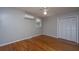 Neutral bedroom featuring a mini-split, hardwood floors, natural light, and a closet for storage at 1369 Miles Dr, Charleston, SC 29407