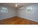 Comfortable bedroom featuring pristine hardwood floors and ample natural light from two windows at 1369 Miles Dr, Charleston, SC 29407