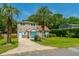 Inviting two-story brick home with light blue shutters and a charming entrance, framed by palm trees at 1369 Miles Dr, Charleston, SC 29407