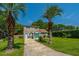 Two-story brick home boasts light blue shutters and a lush, well-manicured front yard with palm trees at 1369 Miles Dr, Charleston, SC 29407