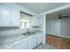 Well-lit kitchen boasting white cabinets, granite countertops, and views into the dining and living spaces at 1369 Miles Dr, Charleston, SC 29407