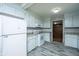 Clean kitchen with updated appliances, neutral countertops, and a view into an adjacent room with built-in shelves at 1369 Miles Dr, Charleston, SC 29407