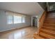 Bright living room featuring wood floors, large windows, neutral walls, and a staircase with wooden railings at 1369 Miles Dr, Charleston, SC 29407