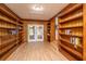 Living room with wood paneling, built-in bookshelves, and hardwood floors and view to backyard at 1369 Miles Dr, Charleston, SC 29407
