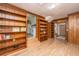 Living room with wood paneling, built-in bookshelves, and hardwood floors at 1369 Miles Dr, Charleston, SC 29407