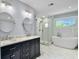 This bathroom features double sinks, a stand-up shower, and a modern standalone bathtub near the window at 1410 Diamond Boulevard, Mount Pleasant, SC 29466