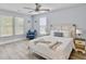 A sunny bedroom featuring a queen bed with a cozy blue armchair and ample natural light from windows at 1410 Diamond Boulevard, Mount Pleasant, SC 29466