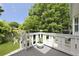 A view from the back porch with chairs and a garden overlooking a beautiful backyard with lush trees and plants at 1493 Little Rock Blvd, Charleston, SC 29412