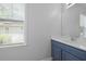 Bright bathroom features a stylish blue vanity with a sink and a window providing natural light and fresh air at 1493 Little Rock Blvd, Charleston, SC 29412