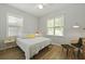 Bedroom with a ceiling fan, light wood floors, and large windows provides a bright and inviting atmosphere at 1493 Little Rock Blvd, Charleston, SC 29412