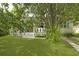 Charming home with a lush front yard and inviting front porch, nestled amongst mature trees at 1493 Little Rock Blvd, Charleston, SC 29412