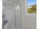 Bathroom shower with glass door next to a window overlooking trees at 1514 Stanwick Dr, Johns Island, SC 29455