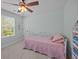 Bedroom featuring a pink quilted bed, ceiling fan and a window overlooking trees at 1514 Stanwick Dr, Johns Island, SC 29455