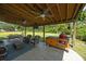 Relaxing covered patio featuring comfortable seating, an outdoor kitchen with a grill, and a view of the spacious backyard at 1514 Stanwick Dr, Johns Island, SC 29455