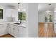 Bright kitchen featuring white cabinets, modern countertops, and a black faucet, adjacent to an open, airy room at 1530 Fort Johnson Rd # 2E, Charleston, SC 29412