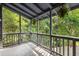 Screened porch with grey wooden deck overlooking lush greenery, offering a serene outdoor space at 1530 Fort Johnson Rd # 2E, Charleston, SC 29412