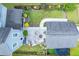 Aerial view of a backyard featuring a patio with fire pit and manicured lawn with colorful flower beds at 1726 Winfield Way, Charleston, SC 29414