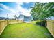 Well-kept backyard with vibrant green grass, gated wood fence, and colorful landscaping at 1726 Winfield Way, Charleston, SC 29414