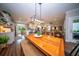 Bright dining area with wooden table, bench seating, and modern light fixture opens to kitchen and living room at 1726 Winfield Way, Charleston, SC 29414