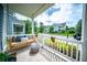 Inviting front porch with a comfortable swing, decorative pillows, and views of the street at 1726 Winfield Way, Charleston, SC 29414
