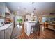 Open-concept kitchen with white cabinetry, stainless appliances, hardwood floors, and seating at the island at 1726 Winfield Way, Charleston, SC 29414