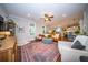 Open-concept living room with leather sofa, area rug, ceiling fan, and seamless flow to dining and kitchen areas at 1726 Winfield Way, Charleston, SC 29414