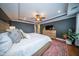 Airy primary bedroom featuring a ceiling fan, tray ceilings, wood floors, and a view of the en suite bathroom at 1726 Winfield Way, Charleston, SC 29414