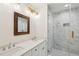 Bright bathroom with double sink vanity, decorative mirror, and large walk in shower with marble tiling at 1989 Nitsa St, Johns Island, SC 29455