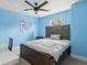 Comfortable bedroom with blue walls features a large bed, ceiling fan, and window view at 1989 Nitsa St, Johns Island, SC 29455
