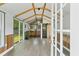 Modern shed interior with wood floors, beamed ceiling, and barn door to the bathroom at 1989 Nitsa St, Johns Island, SC 29455
