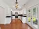 Stylish kitchen with white cabinetry, stainless steel appliances, black countertops, and wood floors at 1989 Nitsa St, Johns Island, SC 29455