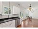 Kitchen with stainless steel appliances and dark counters opens to the sunny dining area and wooden floors at 1989 Nitsa St, Johns Island, SC 29455