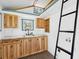 Kitchenette area of the shed with wooden cabinets, a sink, and a ladder to a loft at 1989 Nitsa St, Johns Island, SC 29455